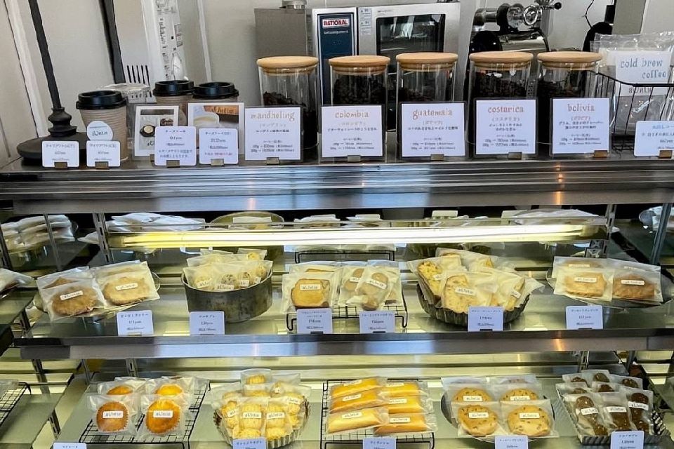 ショーケースの中に焼き菓子、上にコーヒー豆が並んでいる写真