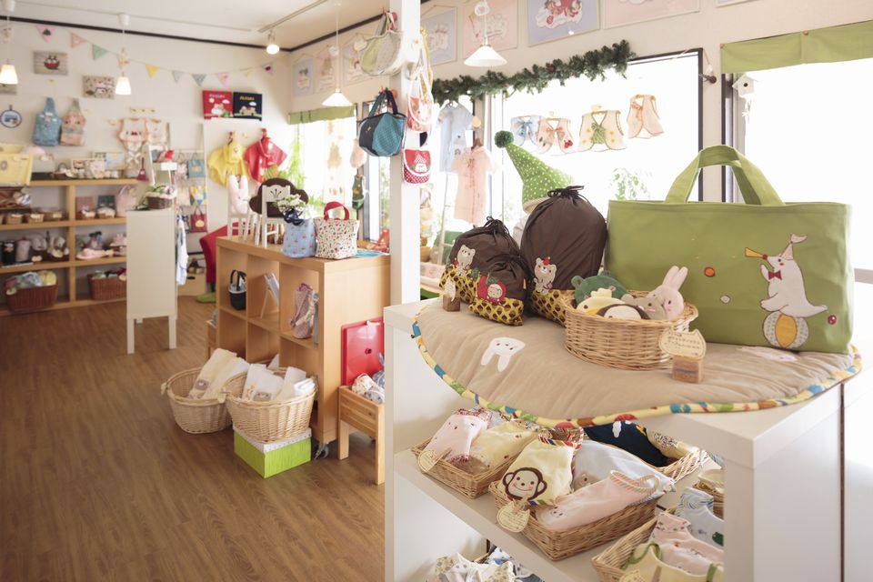 動物の刺繡がされたカバンや小物入れなどが飾ってある店内の写真