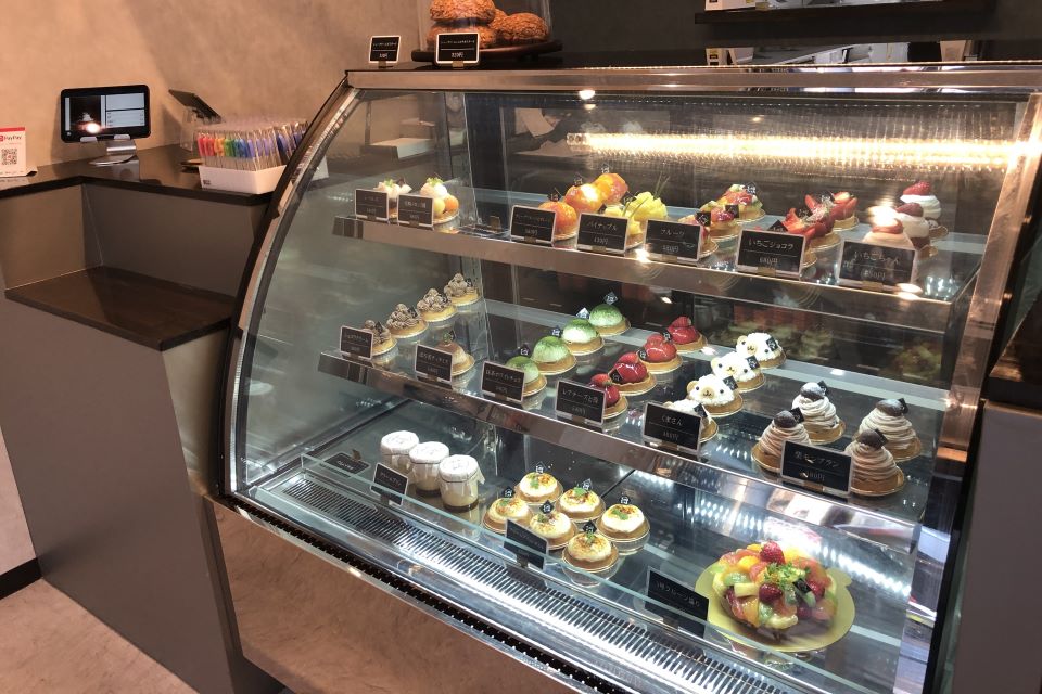色とりどりのケーキが並ぶショーケースの写真
