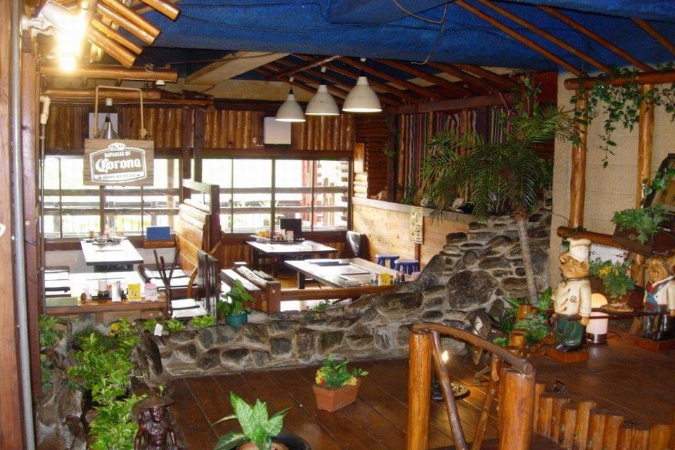 観葉植物の飾られたテーブルが並ぶ店内の写真