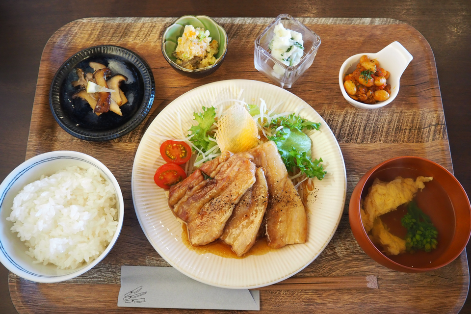 メインの豚肉料理のほか、キノコなどの小鉢や汁物のセットの写真