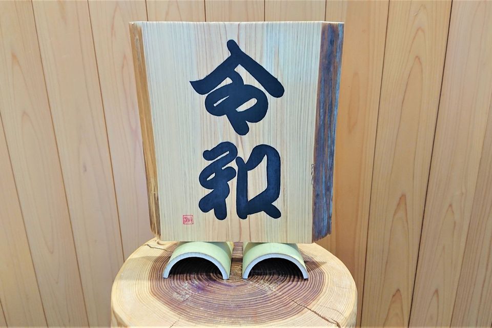 まねき文字で「令和」と書かれた桧の板の写真