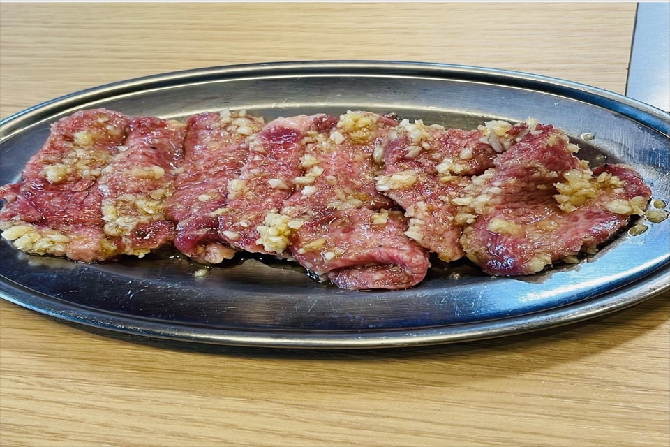 金属トレーに乗ったたれがたっぷりかかった肉の写真