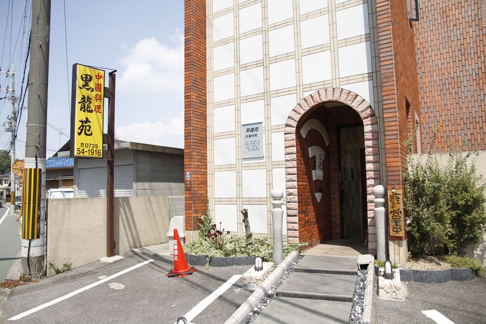 白とベージュのレンガが格子状になっている壁が特徴的な外観写真