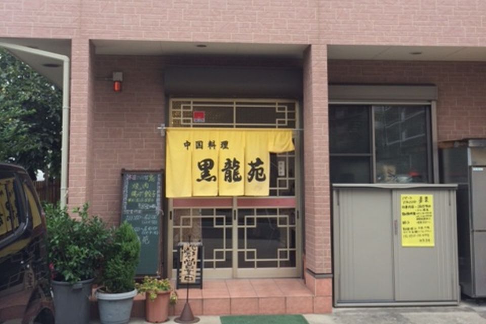 「黒龍苑」と書かれた黄色い暖簾が目印の店の外観写真