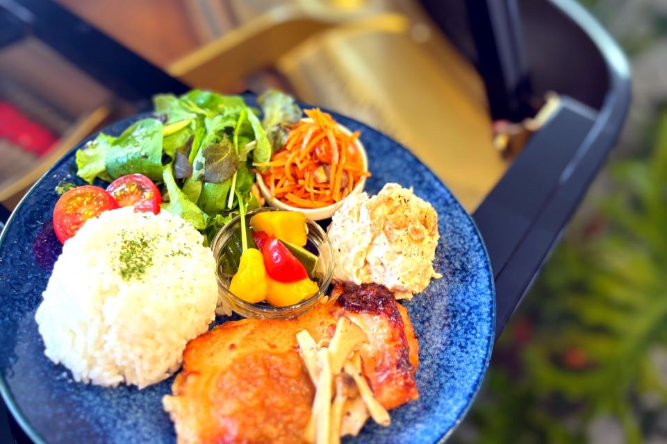 青いプレートにサラダやチキン、ライスが乗った写真