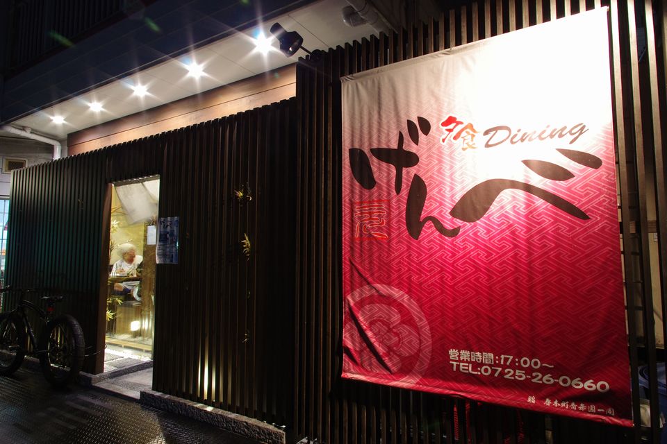 「げんべ」と書かれた赤い布看板が目印の外観写真