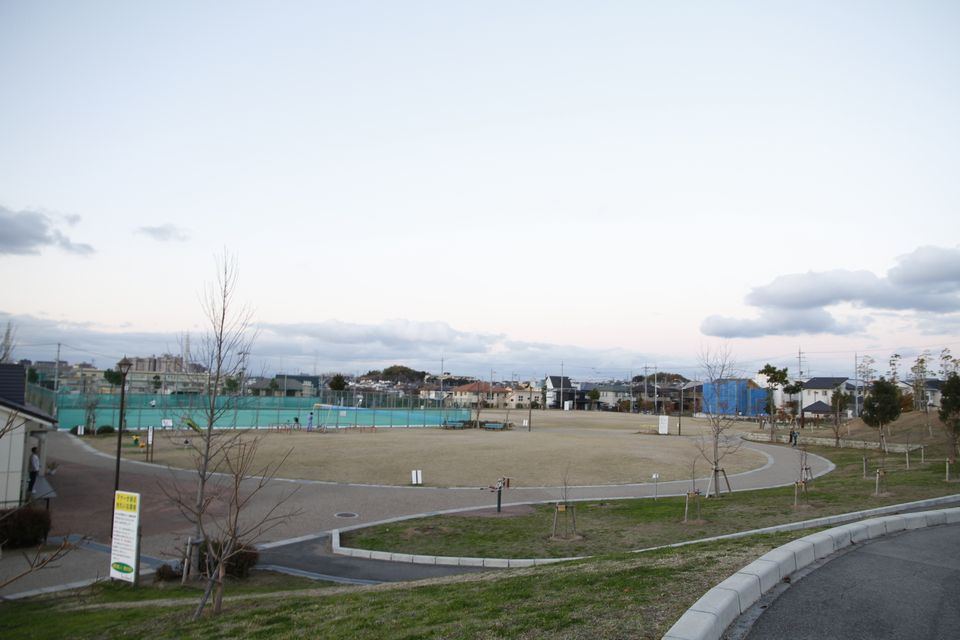 奥にテニスコートのある公園の写真