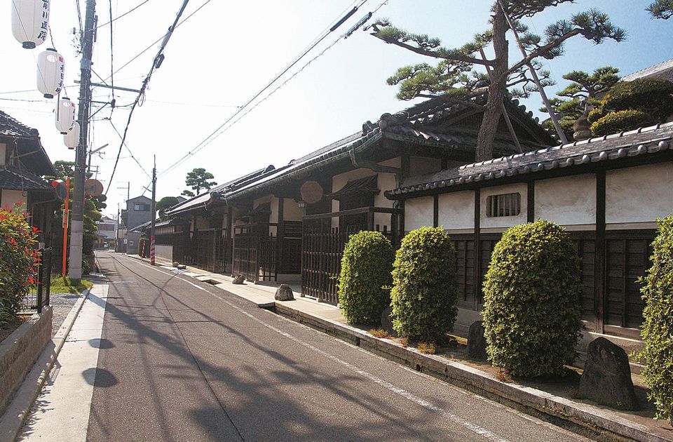 昔ながらの日本家屋の塀が立ち並ぶ道の写真